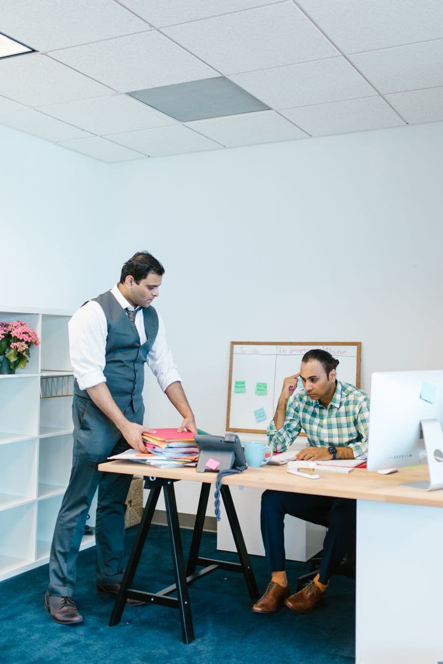Two professionals discussing project plans in a modern office setting.